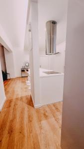 uma cozinha com armários brancos e piso em madeira em Newly Renovated Super-Chic Apartment em Nicósia