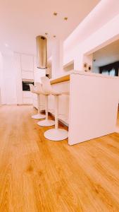 ニコシアにあるNewly Renovated Super-Chic Apartmentのウッドフロアのキッチン(白いテーブル、椅子付)