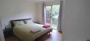 a bedroom with a bed and a large window at Rising Sun in Russell Island