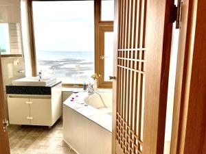 łazienka z umywalką i dużym oknem w obiekcie O2Heal resort w mieście Czedżu