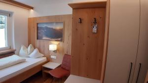 una piccola stanza con un letto e una finestra di Pension Panorama a Solda