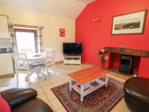 a living room with a table and a red wall at Number 5 in Buxton