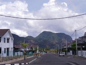 a street in a town with mountains in the background at Aafiyah Guesthouse in Padang Besar