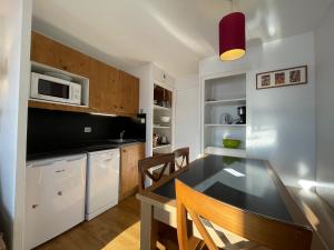 una cucina con tavolo e sedie in una stanza di appartement en duplex alpe d'huez a LʼAlpe-dʼHuez