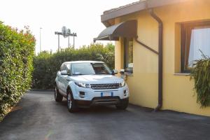 Biały SUV zaparkowany obok budynku w obiekcie Motel Cuore Gadesco - Hotel - Motel - Cremona - CR w mieście Ca deʼ Mari