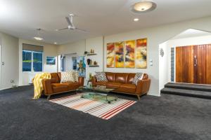 a living room with two couches and a table at Tasman Bay Villa in Nelson
