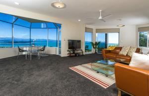 a living room with a couch and a table at Tasman Bay Villa in Nelson +25 photos