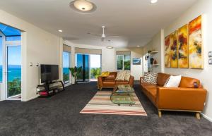 a living room with two couches and a television at Tasman Bay Villa in Nelson