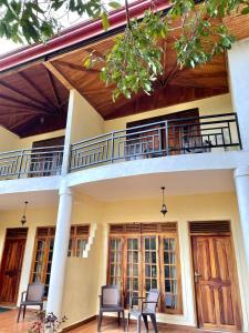 a house with a balcony with chairs on it at Hotel mango tree nearest Adam's peak in Nallathanniya