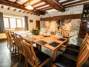 a dining room with a long wooden table and chairs at Maestyddyn Farm House in Clocaenog