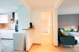 un soggiorno con un divano blu e una cucina di Les chambres du Vercors - Parking Free Fibre Netflix a Fontaine Altre 12 foto