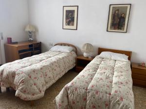 1 dormitorio con 2 camas, mesa y 2 lámparas en Villino Carla en Lipomo