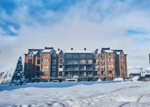 a building with a christmas tree in the snow at Victoria's Panoramic View, ALPIC in Gudauri