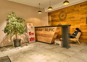 a woman sitting in a chair in a room with a clock at Victoria's Panoramic View, ALPIC in Gudauri