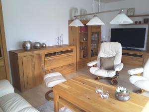 a living room with a tv and a chair and a table at Ferienhaus Käthe in Wutha-Farnroda