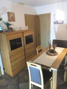 a kitchen with a table and a wooden cabinet at Ferienhaus Käthe in Wutha-Farnroda