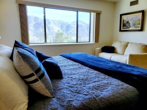 ein Schlafzimmer mit einem Bett mit einer blauen Decke darauf in der Unterkunft Kern River Retreat - Walk to River & Downtown! retreat in Kernville