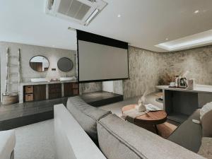 a living room with a couch and a tv at The Cara Boutique Hotel in Kota Kinabalu