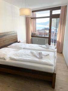 1 Schlafzimmer mit 2 Betten und einem großen Fenster in der Unterkunft Zu Hause am See - Pool, Sauna, Fitnessraum in Schluchsee