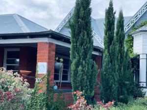 a house with two tall trees in front of it at Town Cottage in Tenterfield