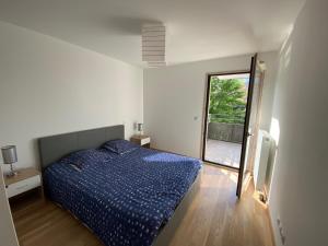 - une chambre avec un lit bleu et une fenêtre dans l'établissement Appartement à quelques minutes du lac d’Annecy - Saint-Jorioz, à Saint-Jorioz