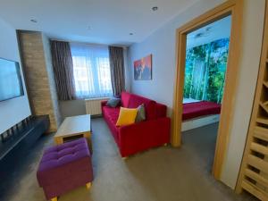 ein Wohnzimmer mit einem roten Sofa und einem Fenster in der Unterkunft Apartmani Stelo Jahorina in Jahorina