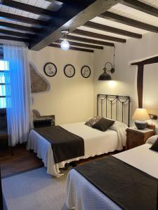 ein Schlafzimmer mit 2 Betten und Uhren an der Wand in der Unterkunft Casa Brandariz in Santa Maria de Arzua