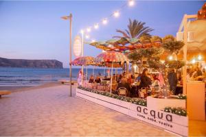a group of people sitting at a restaurant on the beach at Apartamento Miramar in Jávea