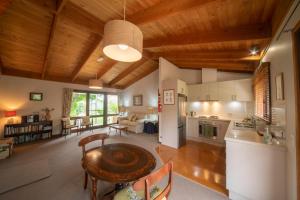 a kitchen and living room with wooden ceilings and a table at The Studio Armidale in Armidale