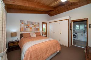a bedroom with a large bed and a kitchen at The Studio Armidale in Armidale