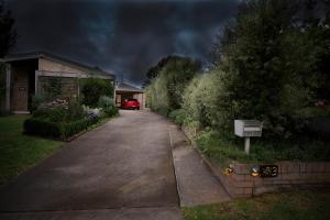a house with a car parked on a driveway at The Studio Armidale in Armidale
