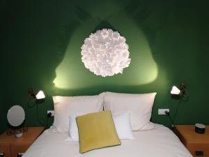 Dormitorio verde con cama blanca y lámpara de araña en Häuschen am Meer, en Vodice