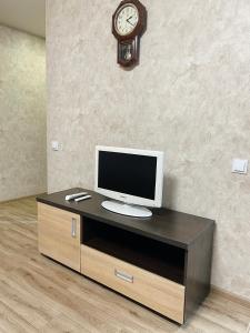 a desk with a tv and a clock on a wall at Apartment - Sobornyi Prospekt 97 in Zaporozhye