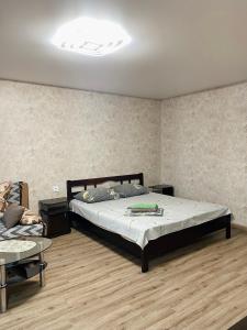 a bedroom with a large bed and a table at Apartment - Sobornyi Prospekt 97 in Zaporozhye