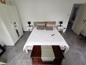 un grande letto in una stanza con due tavoli di Chambre lit double a Chambray-lès-Tours