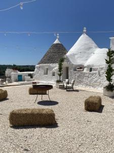 a building with a table and hay bales in front of it at Petranima Wellness in Trulli in Ostuni