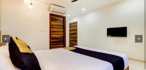 een slaapkamer met 2 bedden en een tv aan de muur bij SERENE INTERNATIONAL in Bangalore