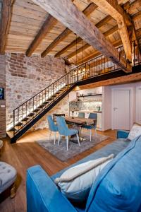 un soggiorno con divano blu e tavolo di Apartments Casa De Amicis a Rovigno (Rovinj)