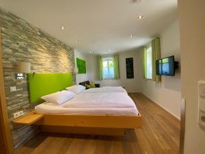 een slaapkamer met een groot bed met een groene muur bij Landhaus Folk in Pleinfeld