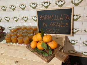 una mesa con un montón de naranjas y tarros de mermelada en B&B Daddanca, en Ales