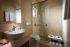 a bathroom with a shower and a sink and a toilet at Astoria Hotel in Agia Galini