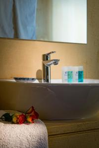 Astoria Hotel في أغيا غاليني: بالوعة في الحمام مع مرآة