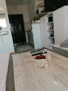 a living room with a basket of roses on the floor at Studio Apartman ZENICA in Zenica