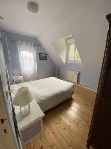 a bedroom with a bed and a table and a window at La Petite Maison - Maison de Campagne aux portes du Perche in Irai +5 photos