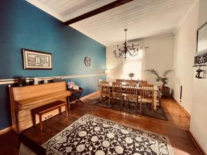 ein Wohnzimmer mit einem Klavier und einem Esszimmer in der Unterkunft The Oak Potch Guesthouse in Potchefstroom