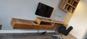 TV en la pared con escritorio y silla en Apartament Górski, en Ustroń