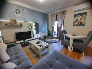 uma sala de estar com um sofá e uma mesa em Apartman Korićanac Vrnjačka Banja em Vrnjačka Banja