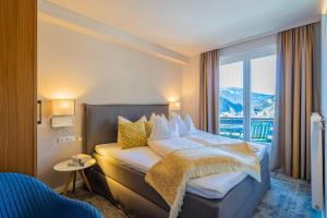 a hotel room with a bed and a balcony at Gästehaus Schusser an der Therme, Frühstück, Doppelzimmer und Ferienwohnung in Bad Kleinkirchheim