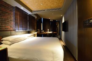 una camera con un grande letto bianco di City Suites - Kaohsiung Pier2 a Kaohsiung