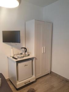 a room with a white cabinet with a television on it at Miriam Rooms Zadar in Zadar